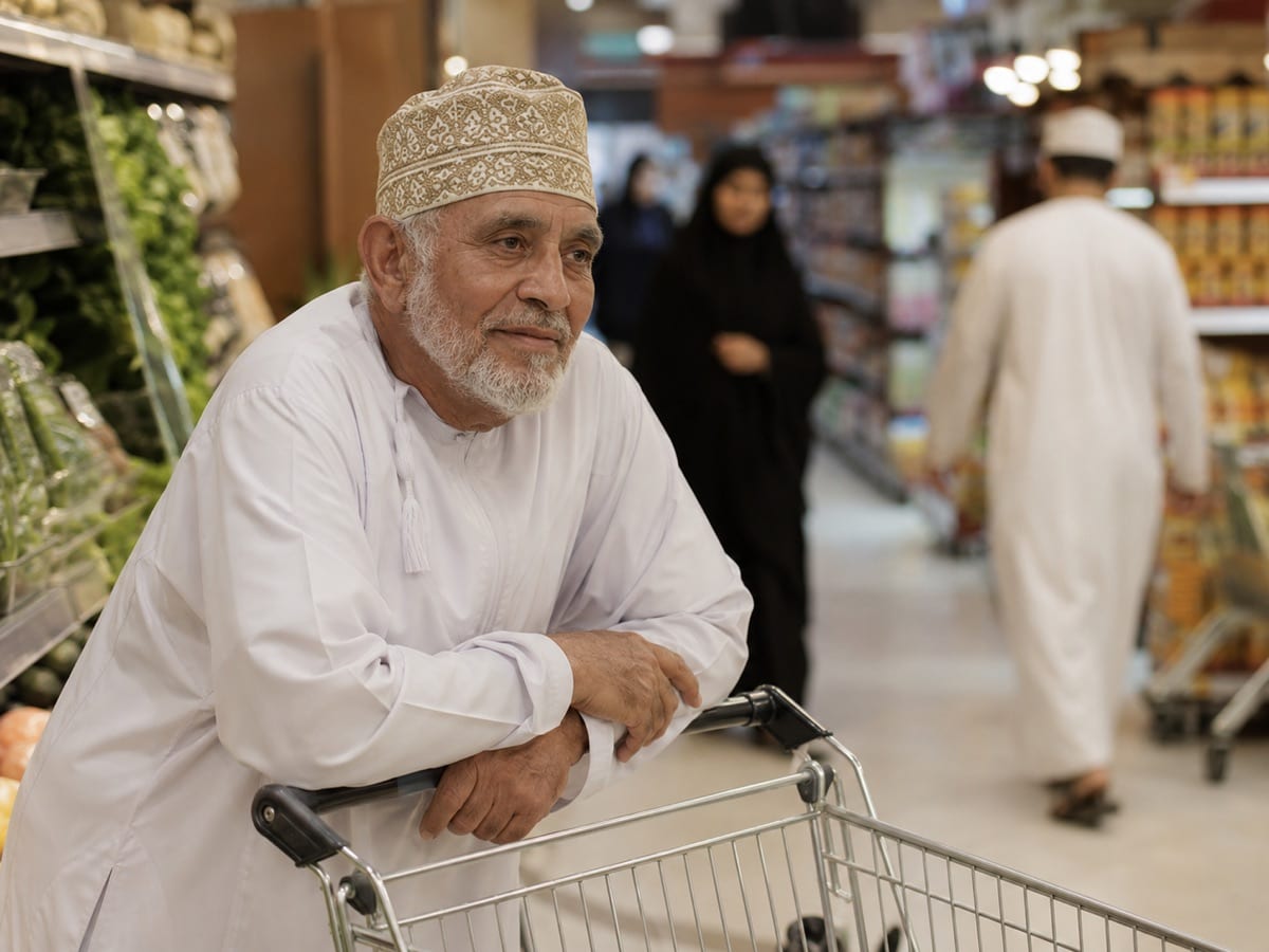 An older adult leaning forward on a shopping trolley, the posture that relieves spinal stenosis pain.
