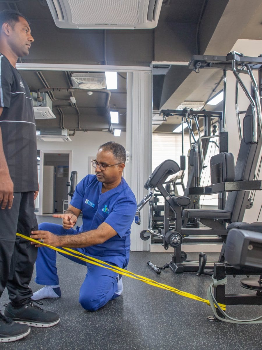 Physiotherapist guiding patient with resistance band
